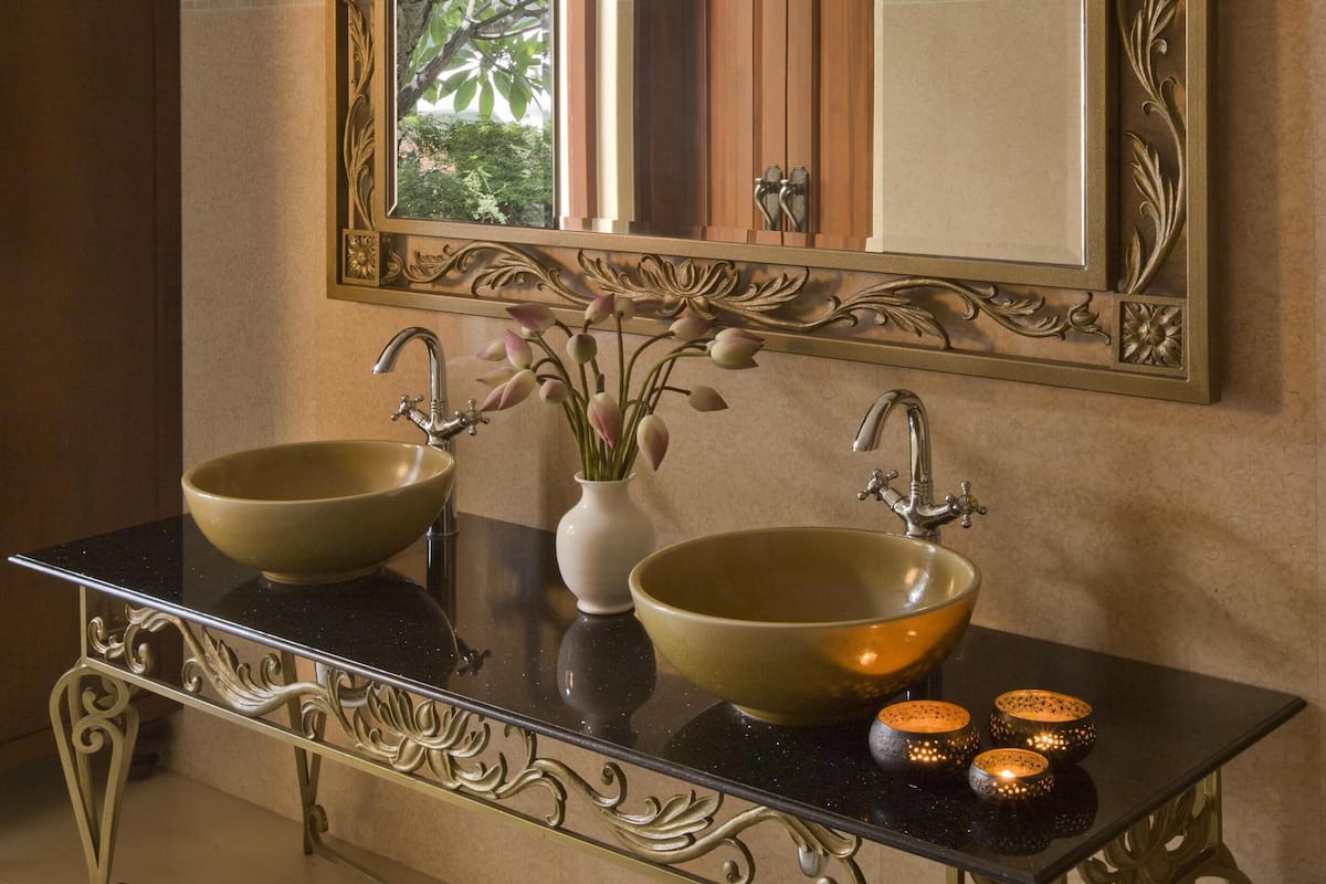 A bathroom with a double sink, a large mirror, and decorative elements.