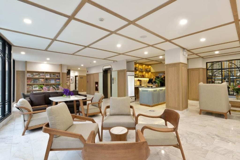 A hotel lobby with a seating area, a bar, and a reception desk.
