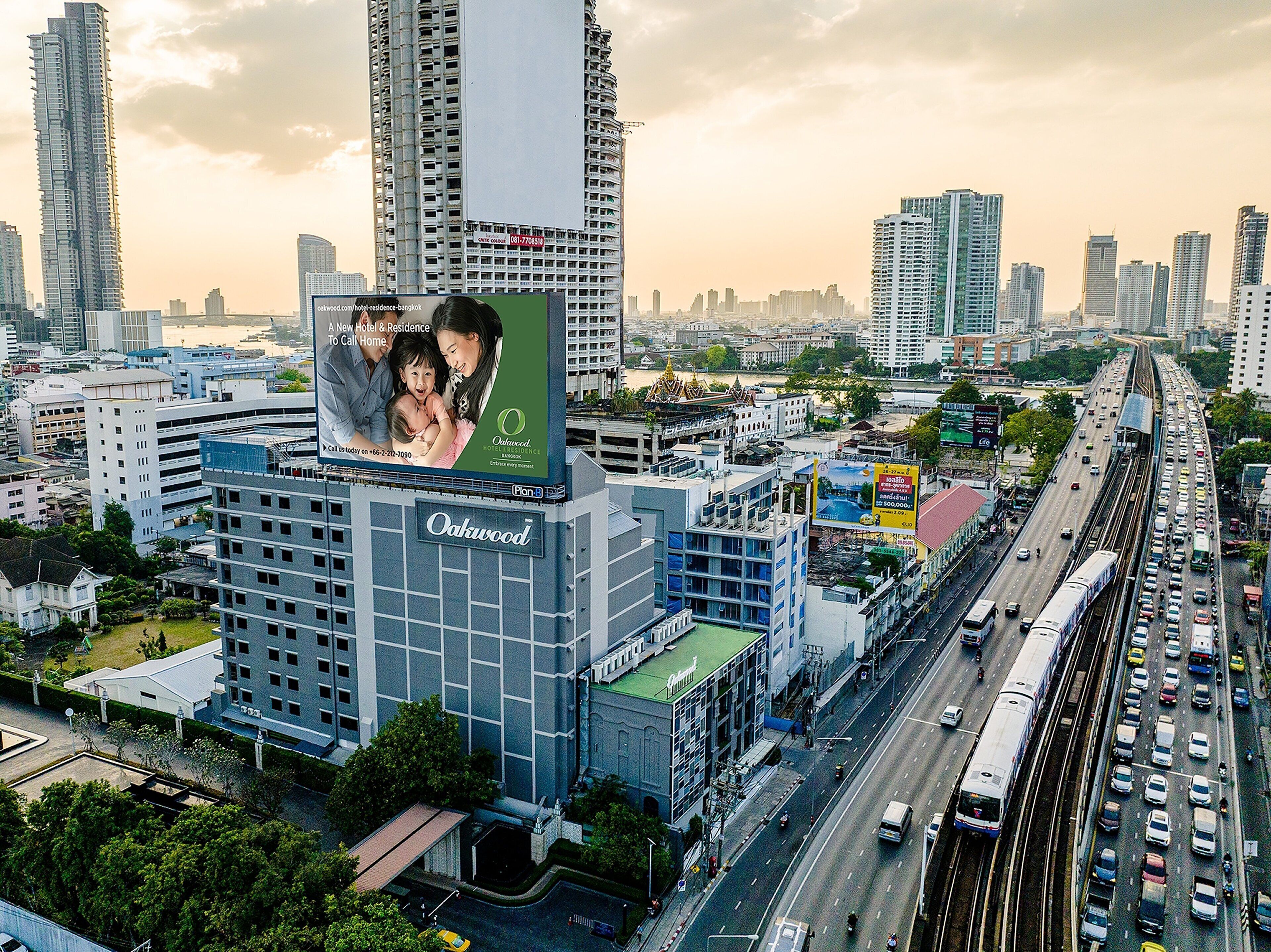 A high-rise building with a prominent billboard advertising a hotel.