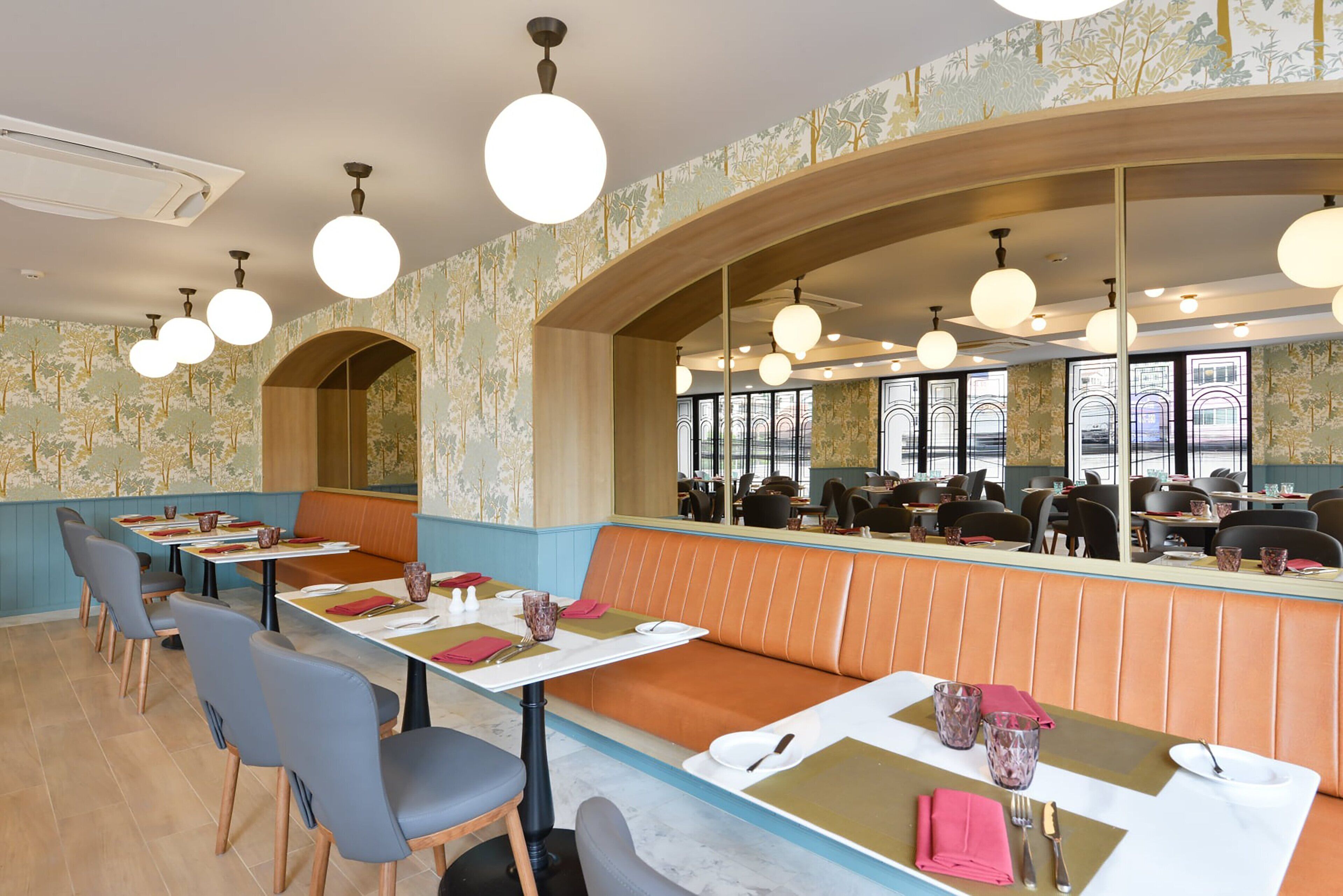 A restaurant with booths and tables, a wooden counter, and a large window.