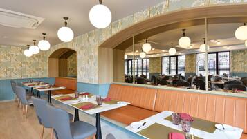 A restaurant with booths and tables, a wooden counter, and a large window.