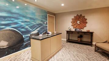 A reception area with a large abstract mural, a wooden console table, and a patterned carpet.