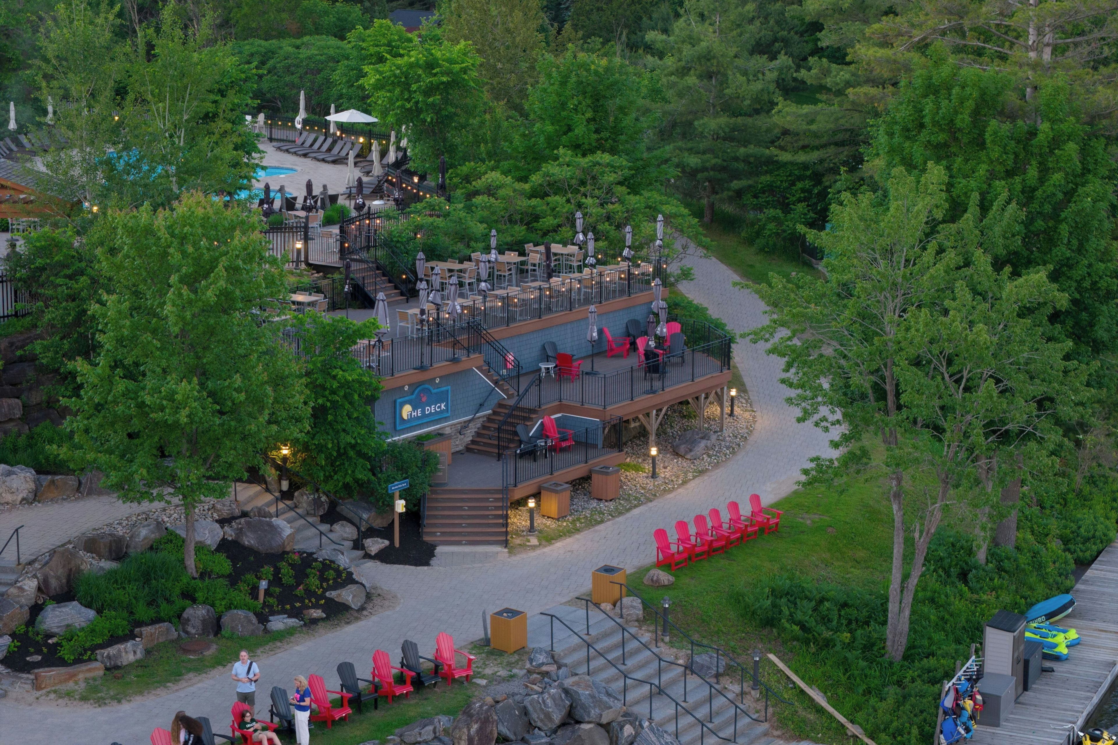 A resort with a pool, outdoor seating, and a deck area.