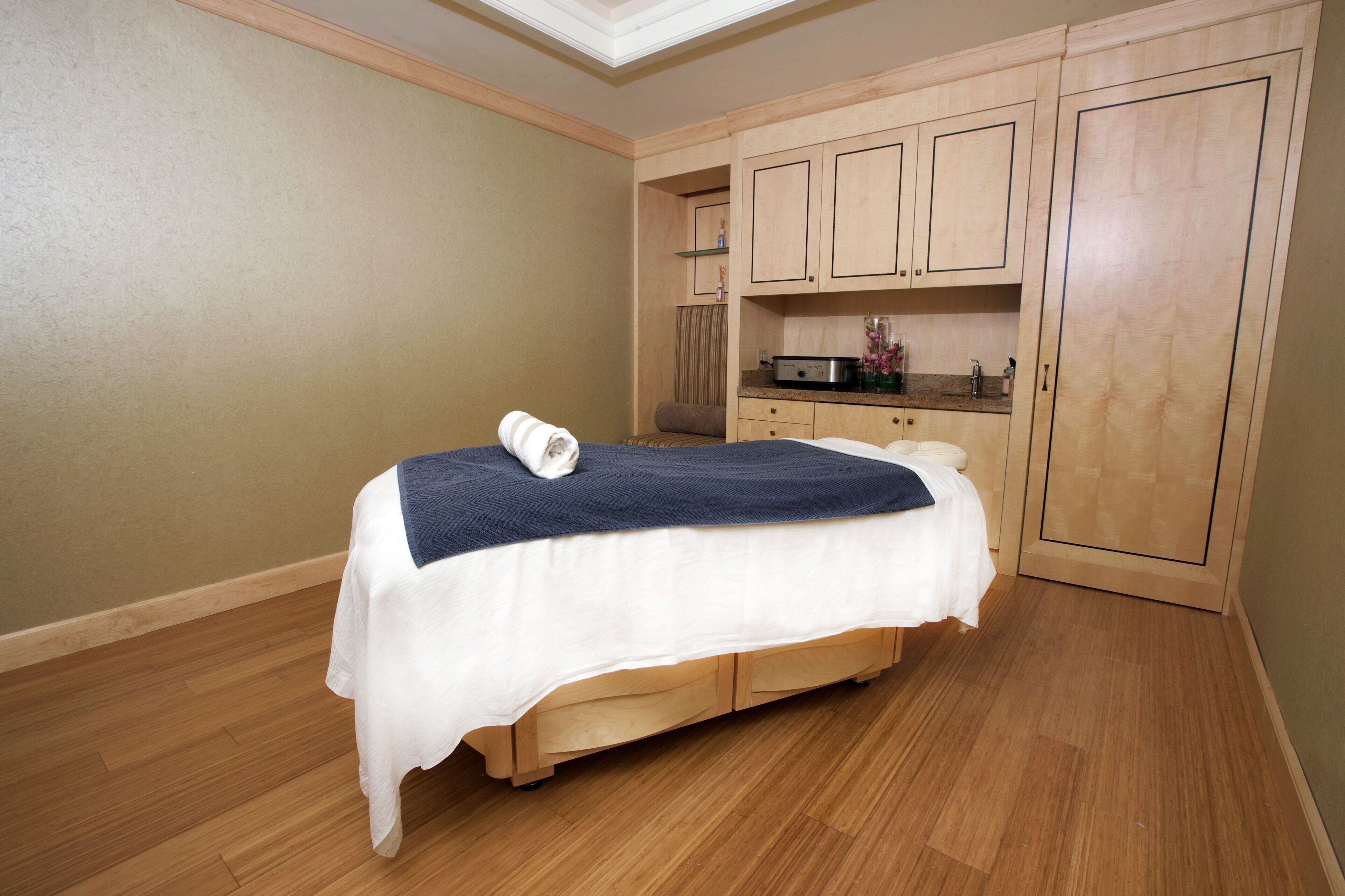 Un dormitorio con una cama, armarios de madera y un tragaluz.