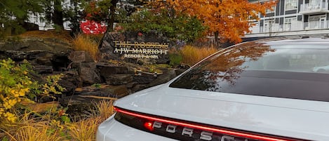 Valkoinen Porsche Taycan Turbo S oli pysäköitynä lähelle kylttiä, jossa ilmoitettiin The Rosseal A JW Marriott Resort & Span sijainti.