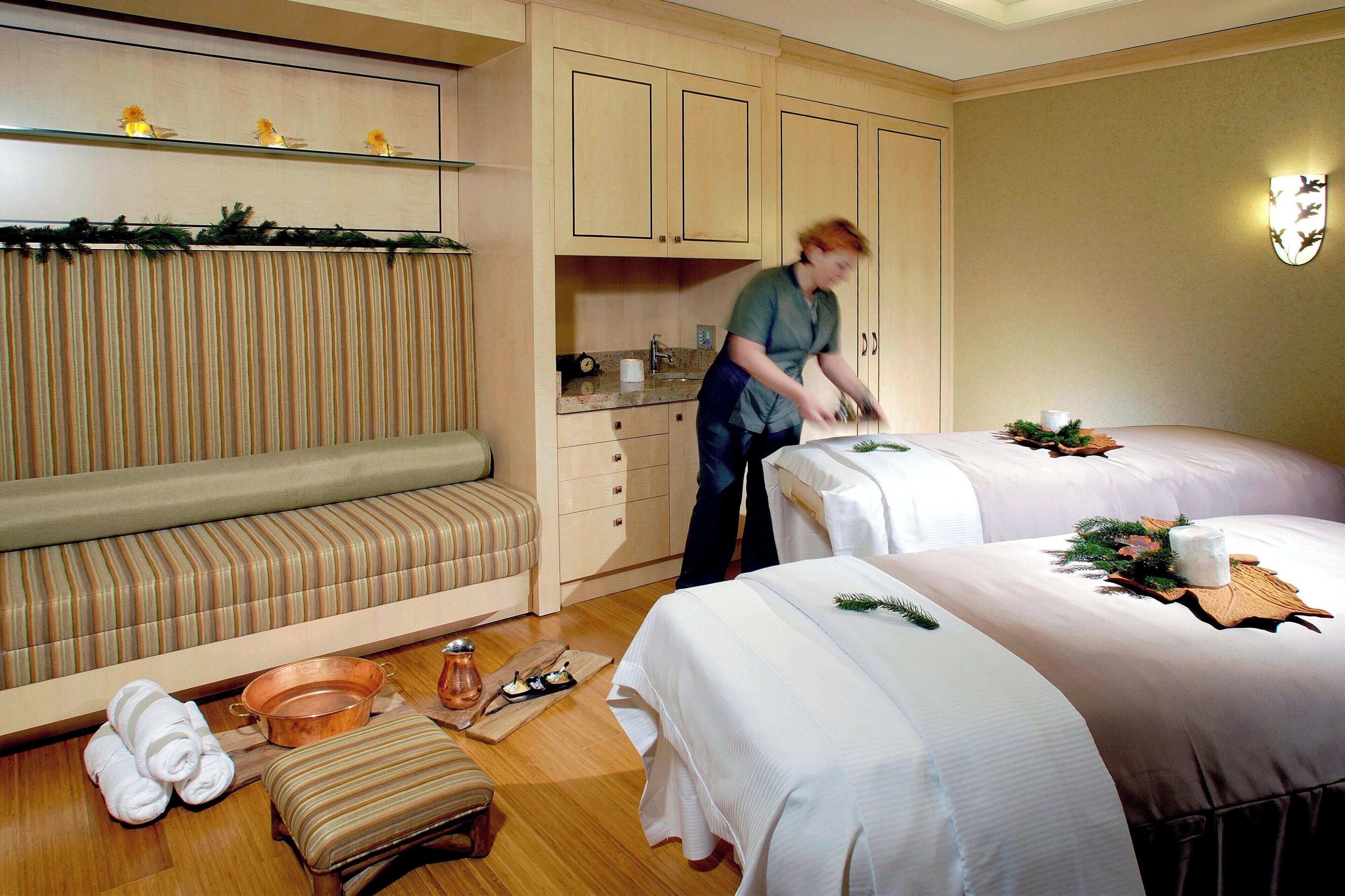 Una habitación de hotel con dos camas, zona de estar, kitchenette y baño.