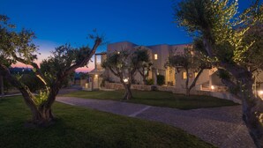 A modern residential building with a paved driveway and well-maintained lawn. - Ourania Apartments (Hersonissos)