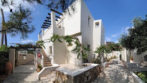 A modern building with a stone pathway leading to a set of stairs. - Ourania Apartments (Hersonissos)