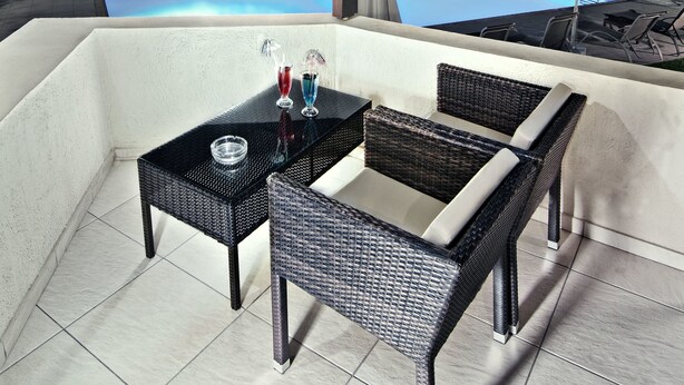 A terrace with a pool, wicker furniture, and umbrellas. - Ourania Apartments (Hersonissos)