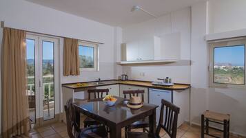 Una cocina moderna con comedor, vistas al exterior y un balcón.