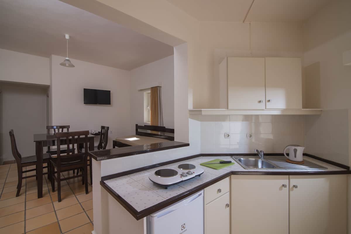 A compact kitchen with a dining area, a microwave, a sink, and cabinets.