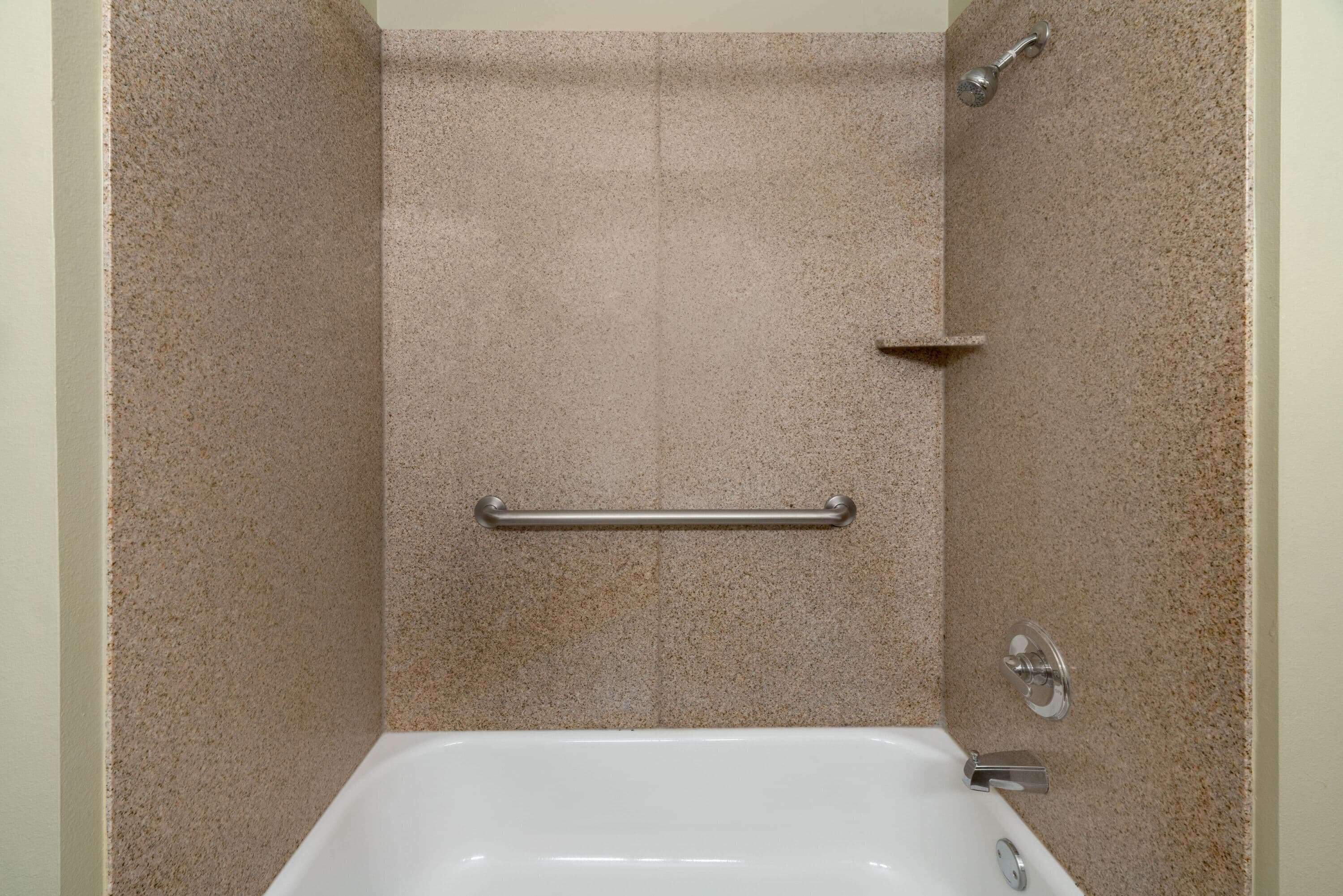 Un baño con bañera, ducha y barandilla.