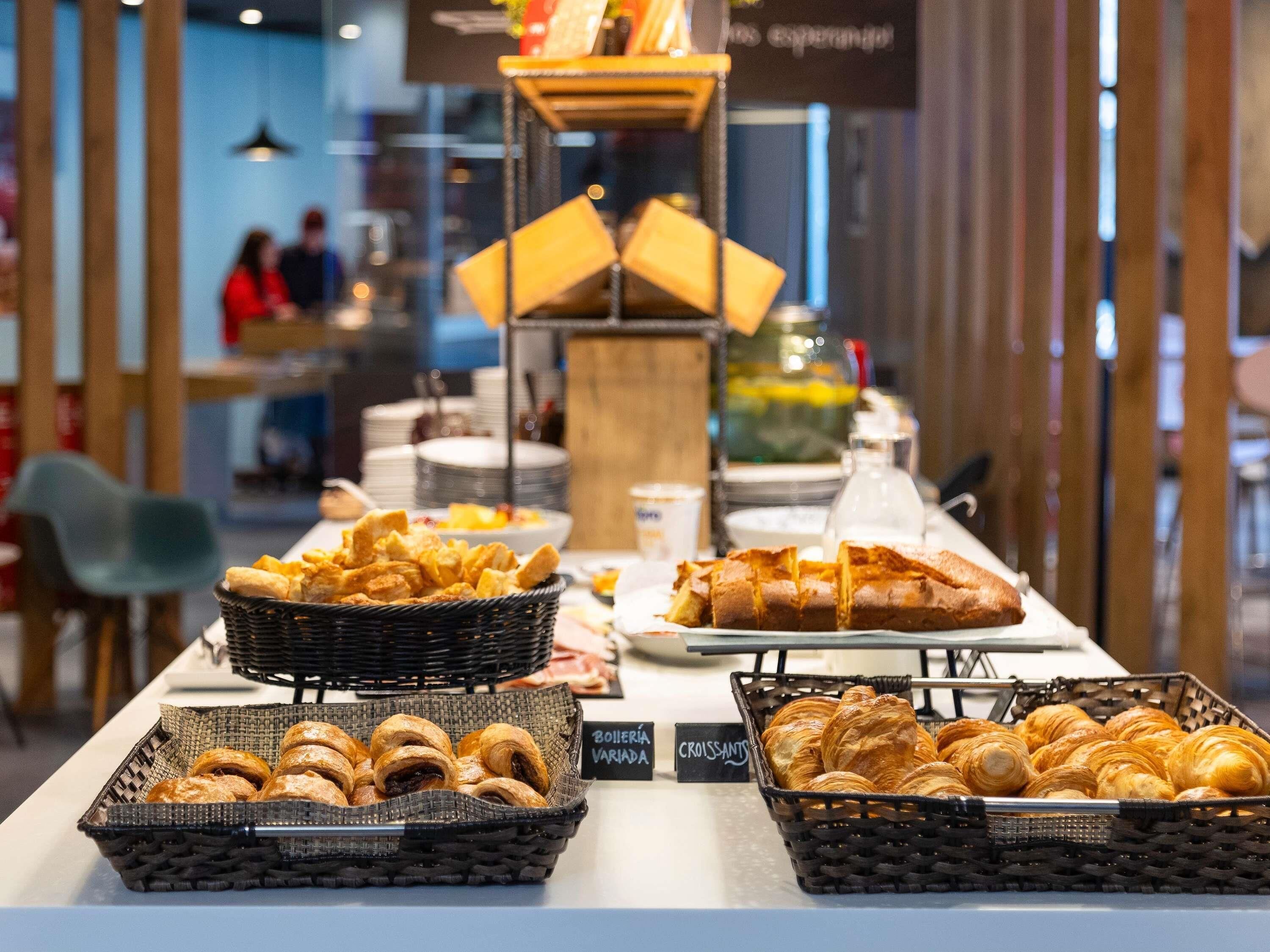 A buffet with various baked goods including croissants and bread.