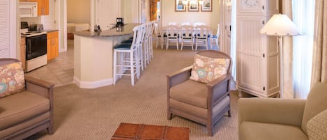 A spacious living area with a kitchen, dining area, and a cozy seating arrangement.