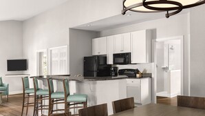 A modern kitchen with white cabinets, a black refrigerator, and a built-in microwave. - Club Wyndham at the Cottages (North Myrtle Beach)