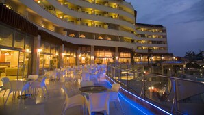 Un hôtel à plusieurs étages doté d’une terrasse et d’un espace piscine.