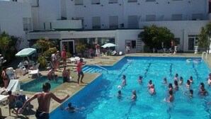 A swimming pool area with multiple pools, lounge chairs, and umbrellas. - San Remo Resort Hotel (Santa Teresita)