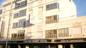 A multi-story building with a sign for "San Remo Resort Hotel" and a "Salon de Convenciones - Ezequiel." - San Remo Resort Hotel (Santa Teresita)