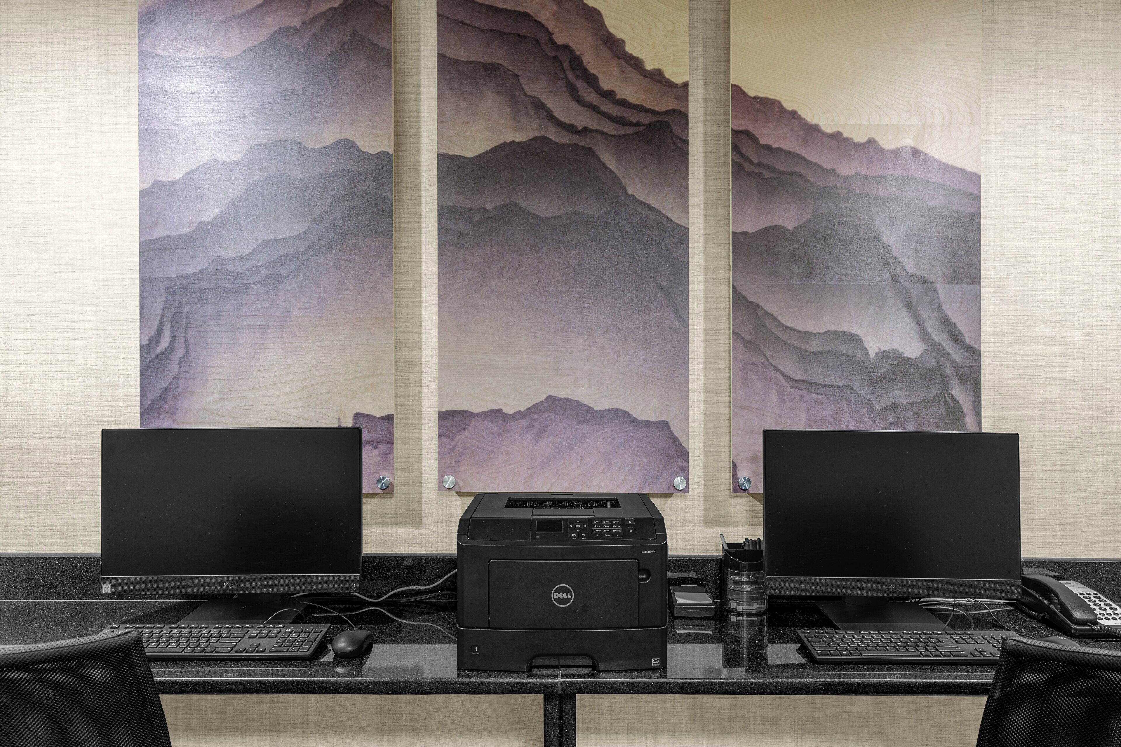 A workspace with two monitors, a printer, and a keyboard.