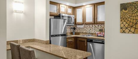 A compact kitchen with a built-in refrigerator, microwave, and dishwasher.