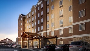 A multi-story hotel with a brick facade, a covered entrance, and several parked cars. - Staybridge Suites Chattanooga at Hamilton Place by IHG (Chattanooga)