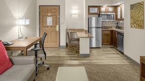 A compact hotel room with a kitchenette, a dining area, and a seating area. - Staybridge Suites Chattanooga at Hamilton Place by IHG (Chattanooga)