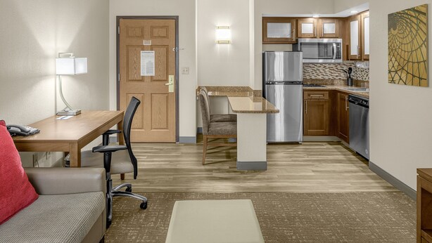 A compact hotel room with a kitchenette, a dining area, and a seating area. - Staybridge Suites Chattanooga at Hamilton Place by IHG (Chattanooga)