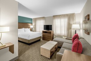 A hotel room with a bed, a desk, a television, a sofa, and a window with curtains. - Staybridge Suites Chattanooga at Hamilton Place by IHG (Chattanooga)