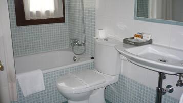 A bathroom with a toilet, a bathtub, and a sink.