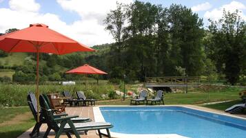Een seizoensgebonden buitenzwembad, parasols voor strand/zwembad