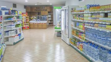 Un'area dedicata alla panetteria con scaffali pieni di prodotti da forno e una vetrina refrigerata.