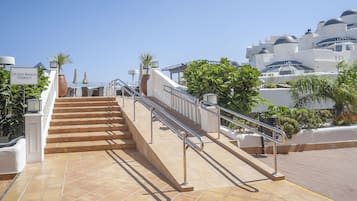 Udendørs trapper fører op til en terrasse med et skilt, der viser "Ocean Breeze Terrace".