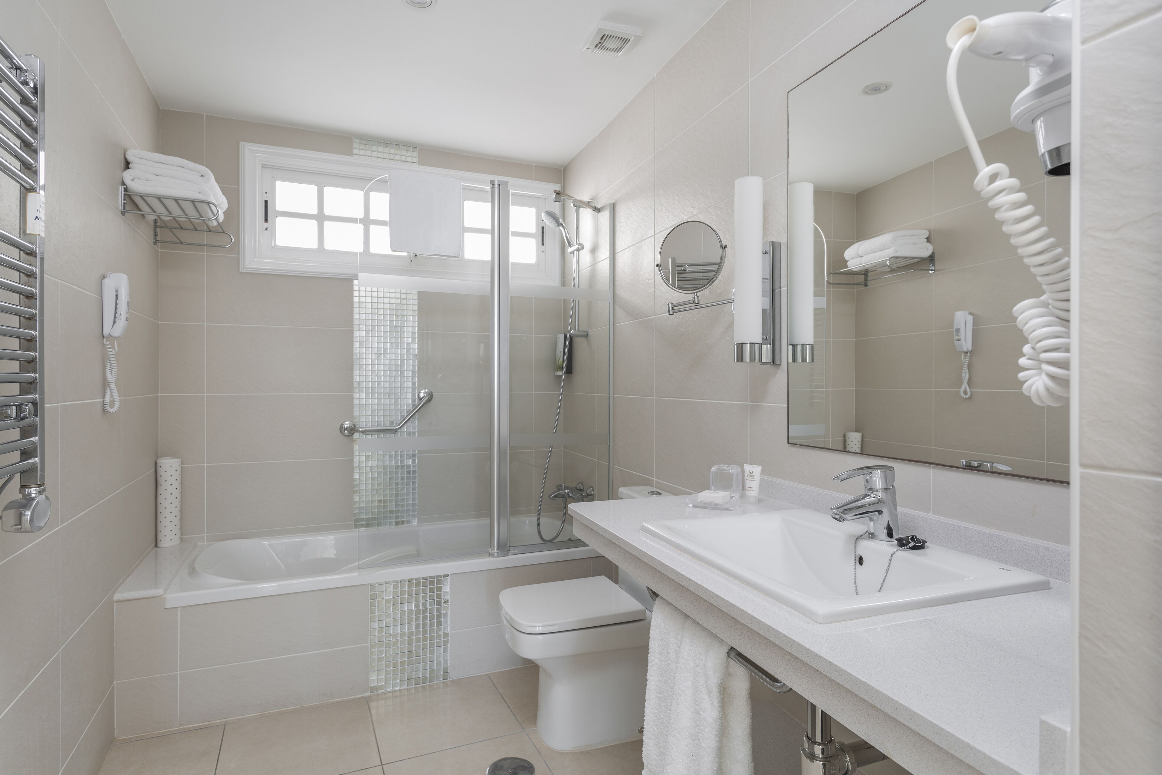 A modern bathroom with a bathtub, toilet, and sink.
