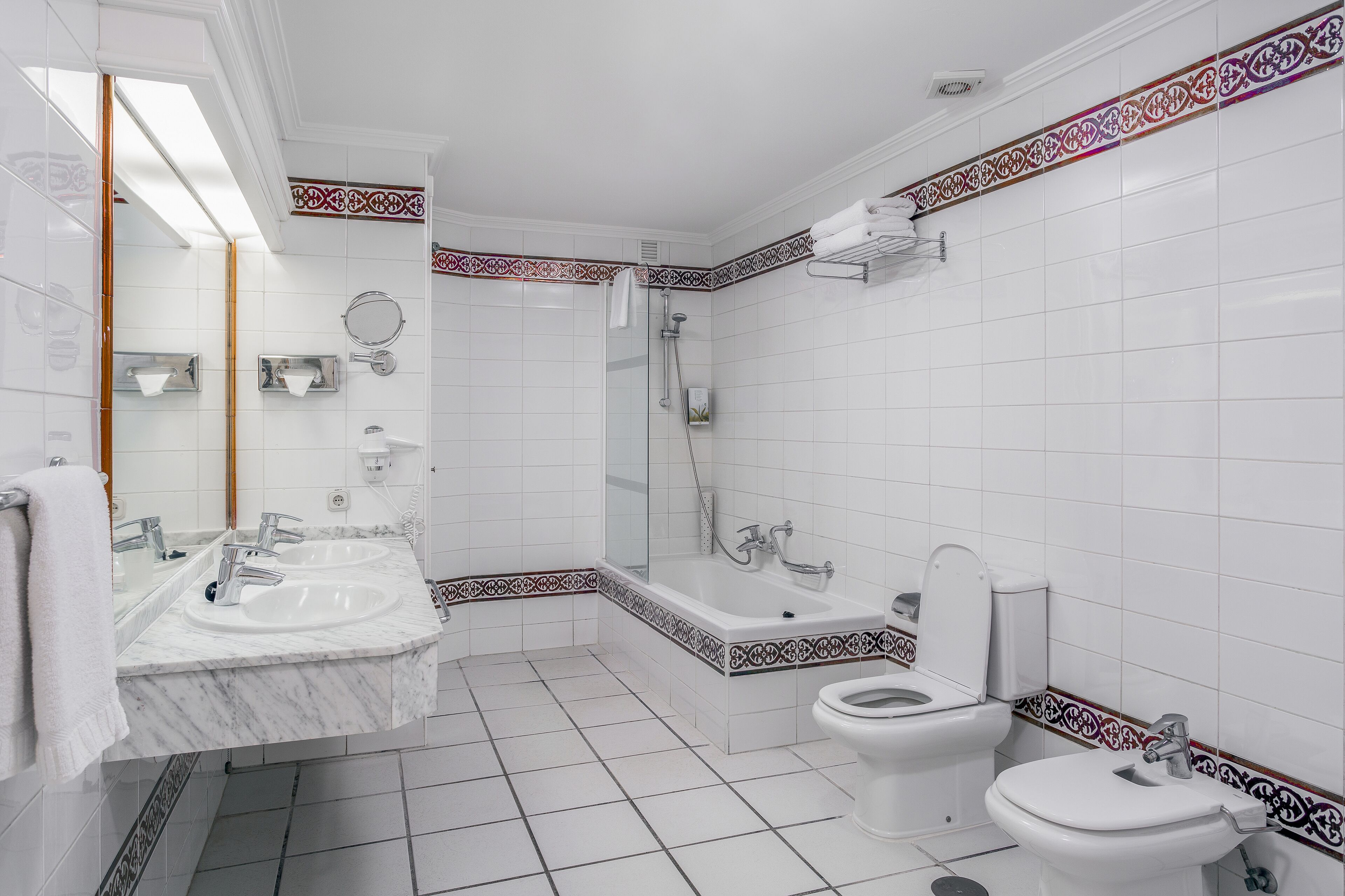 Une salle de bain moderne avec un double vasque, une baignoire et des toilettes.