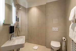 A modern bathroom with a sink, toilet, and shower. - DaunTown Rooms - Self Check-In (Vienna)