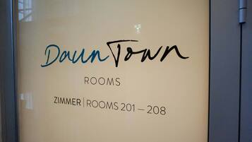 Señal que indica 'Dawn Town' y 'Habitaciones 201-208' en un hotel.