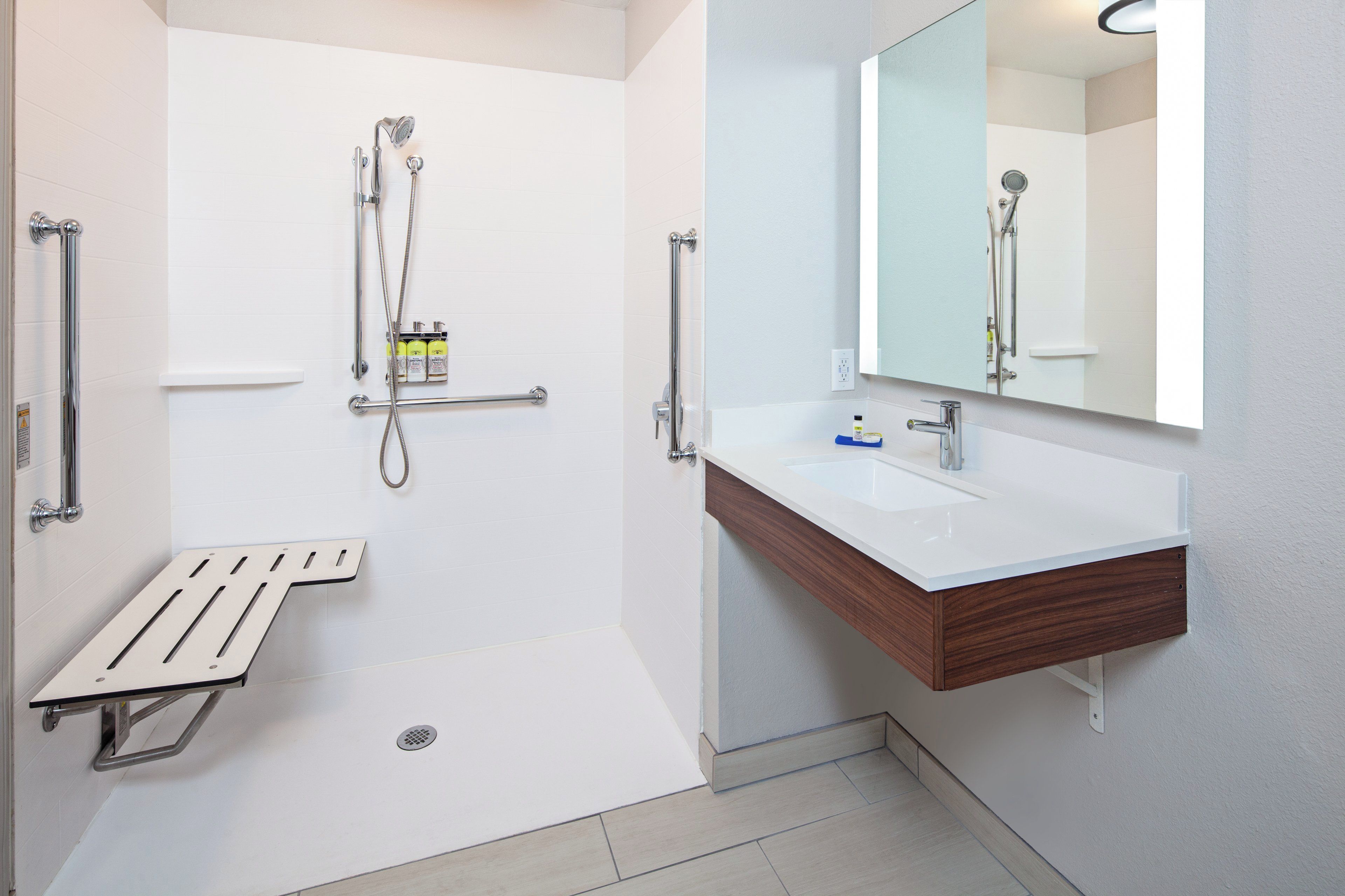 A modern bathroom with a shower, a sink, and a mirror.