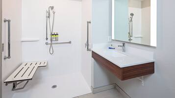 A modern bathroom with a shower, a sink, and a mirror.