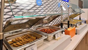 A buffet with labeled trays of turkey sausage, bacon, and cookies. - Holiday Inn Express & Suites Clovis-Fresno Area by IHG (Clovis)