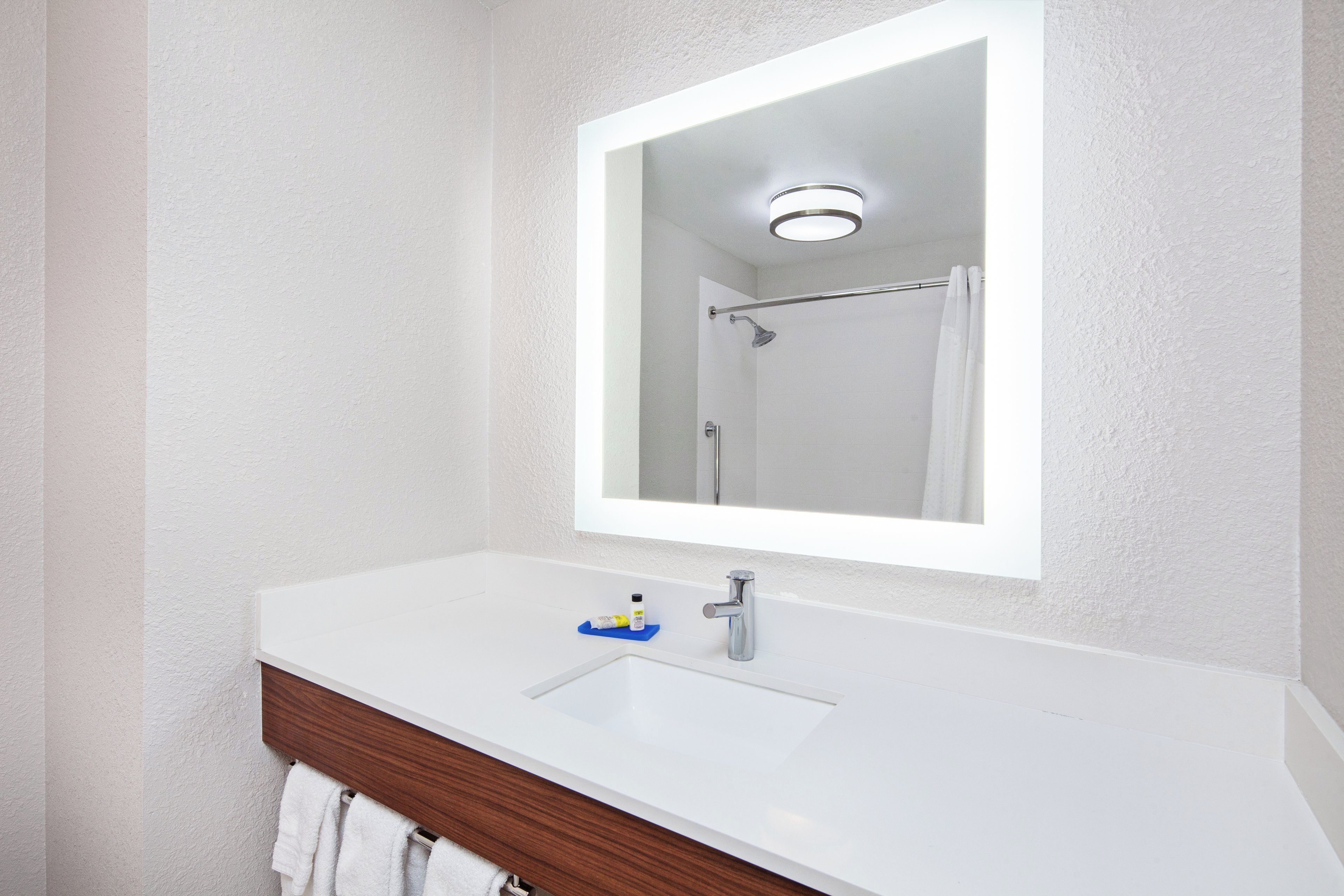 A bathroom with a white sink, a mirror, and a shower curtain.