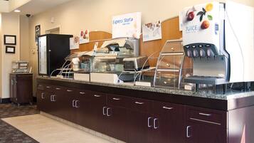 Disposição de buffet com estação de sucos e diversas opções de comida.