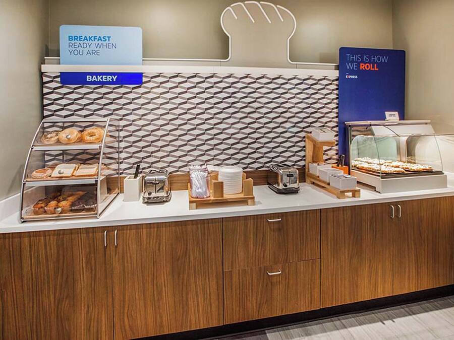 A breakfast buffet with a bakery section, a coffee station, and a sign indicating the availability of breakfast.
