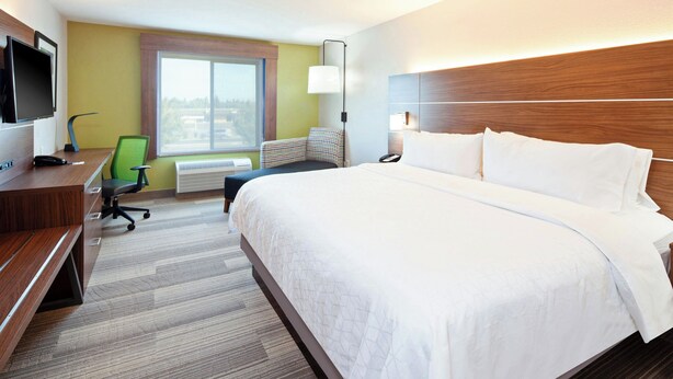 A hotel room with a large bed, a desk with a computer, a chair, and a TV. - Holiday Inn Express & Suites Clovis-Fresno Area by IHG (Clovis)