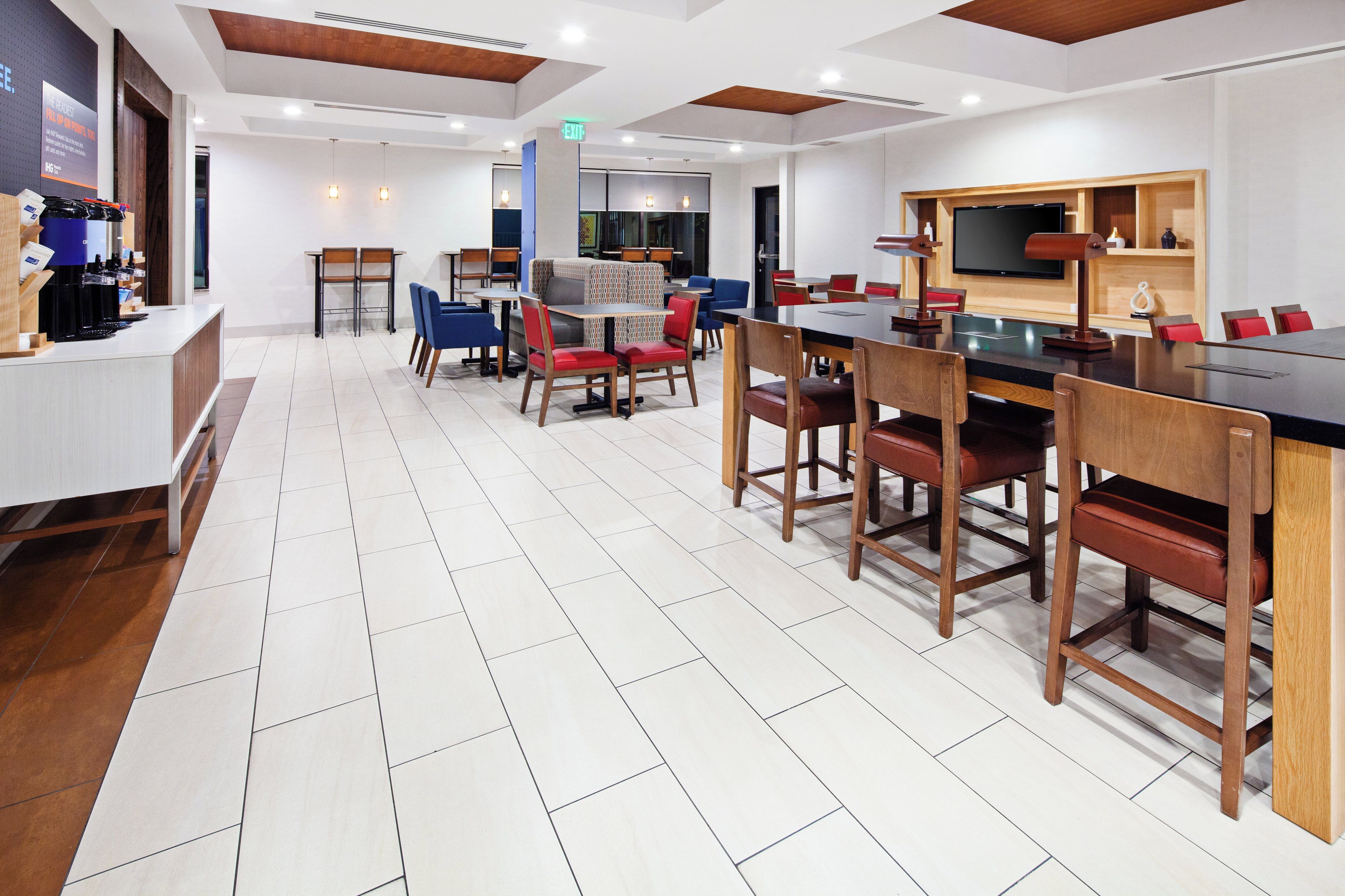 Un moderno vestíbulo de hotel con mostrador de recepción, zona de estar y bar.