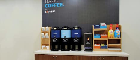 A coffee station with multiple coffee dispensers, a hot water station, and various coffee products on shelves.