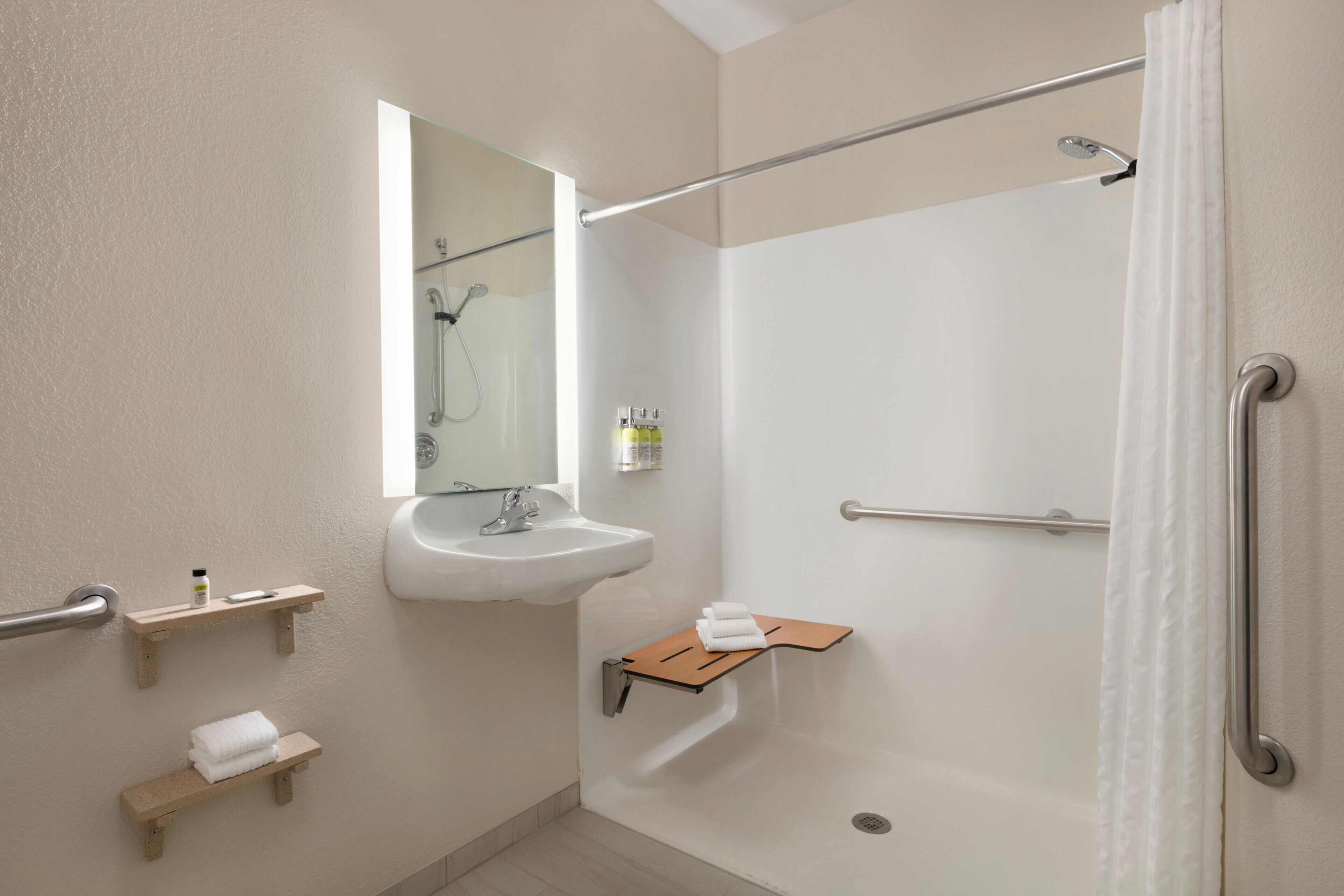 A modern bathroom with a shower, a sink, and towel racks.