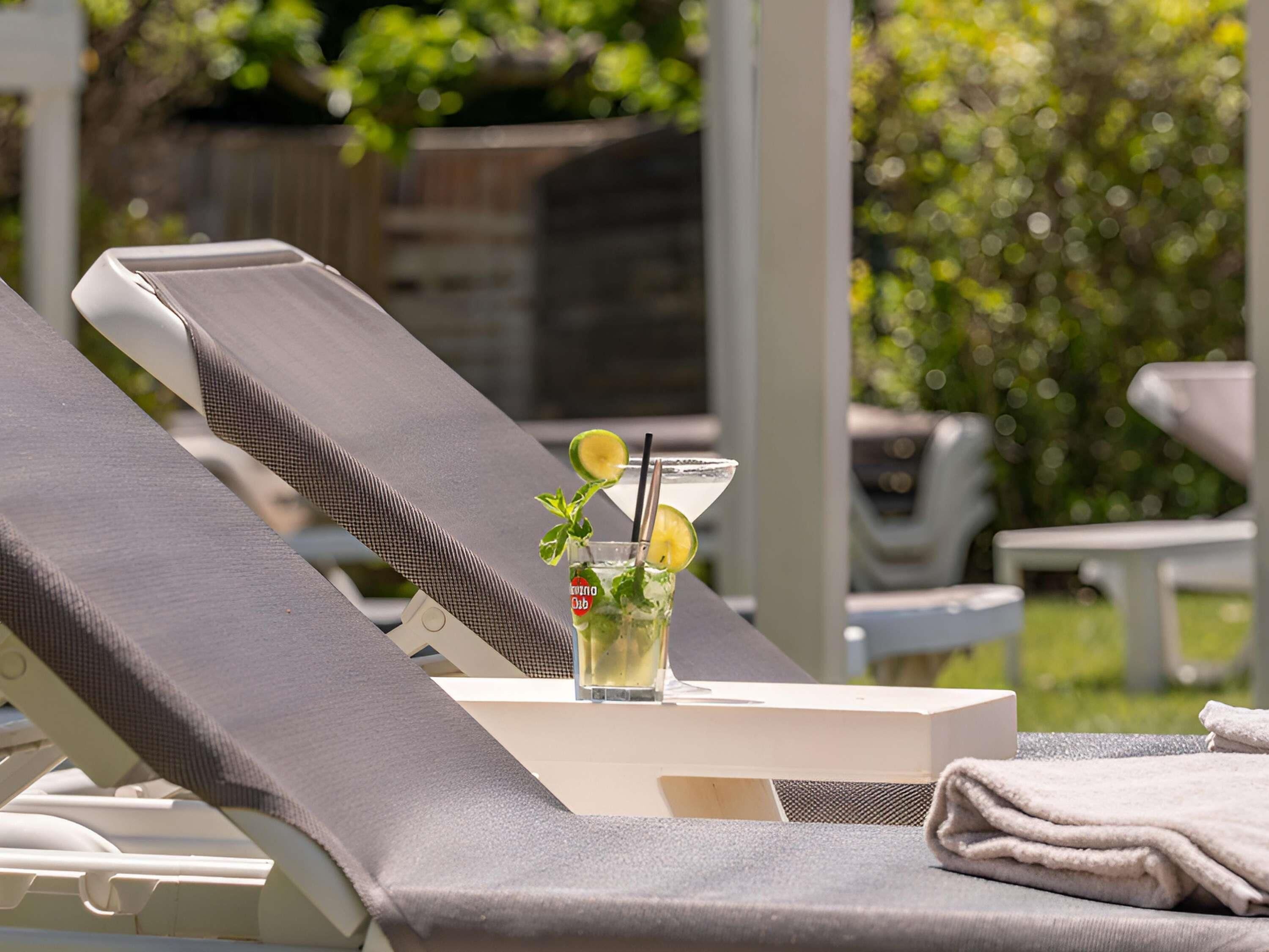 Una piscina al aire libre, sillones reclinables de piscina