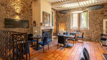 Een restaurant met stenen muren, een open haard en een menubord.