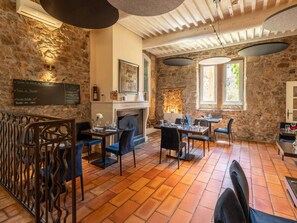A restaurant with stone walls, a fireplace, and a menu board. - Hotel Mercure Aix en Provence Sainte Victoire (Chateauneuf-le-Rouge)