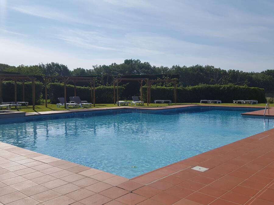 Una piscina al aire libre, tumbonas